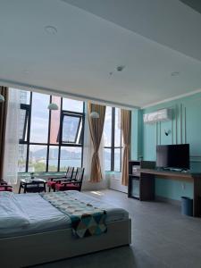 1 dormitorio con 1 cama y escritorio con TV en Ngoc Khanh hotel, en Nha Trang