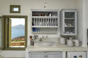encimera de cocina con fregadero y ventana en Ochre Dream, Beach front & Sunset villa Naousa, en Naousa