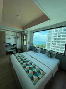 Cama grande en habitación con ventana grande en Ngoc Khanh hotel, en Nha Trang
