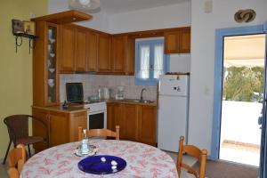 eine Küche mit einem Tisch und einem weißen Kühlschrank in der Unterkunft Lia's Home in Mármara