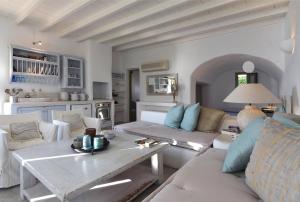 a living room with a couch and a table at Ochre Dream, Beach front & Sunset villa Naousa in Naousa