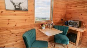 een eetkamer met een tafel en stoelen en een raam bij Shepherds Hut by Stepney Stays in Scarborough