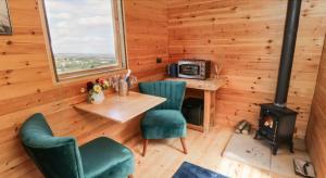 a room with a table and chairs and a stove at Shepherds Hut by Stepney Stays in Scarborough