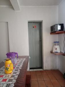 a room with a table and a door with a microwave at Casa em Diamantina in Diamantina
