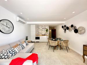 a living room with a couch and a clock on the wall at Loft 18 Beachfront Marbella Center in Marbella