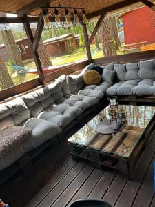 un sofá grande en una terraza de madera en Domek Wakacyjny Maciuś 48 en Głębokie