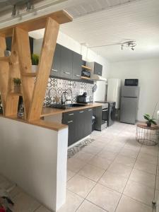a kitchen with black cabinets and a white tile floor at La Symphorine in Grandvilliers