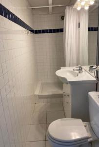 a white bathroom with a toilet and a sink at Joli studio en plein centre ville - Nyons in Nyons
