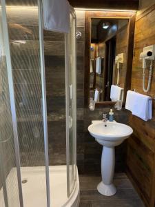 a bathroom with a glass shower and a sink at Villa Sagan in Zamárdi