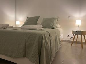 Un dormitorio con una cama con sábanas verdes y una mesa. en Le petit prince, en Balaruc-les-Bains