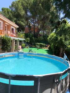 uma grande piscina num quintal com um campo de golfe em Casa Rural Pantano de San Juan em Pelayos de la Presa