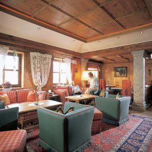 Hotel Garni Serfauserhof في سيرفاوس: وجود رجل جالس في مطعم به طاولات وكراسي