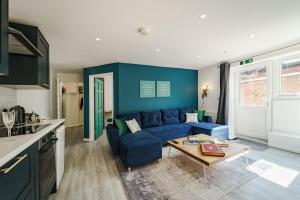 a living room with a blue couch and a table at The Adelphi Aparthotel in Stratford-upon-Avon