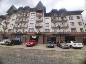 un gran edificio con coches estacionados frente a él en Apart Pro en Úzhgorod