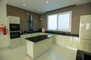 a large kitchen with a sink and a window at The One chalet Oman in Bū ‘Abālī