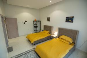 two beds in a room with yellow sheets at The One chalet Oman in Bū ‘Abālī +12 photos