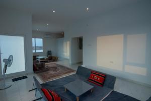 uma sala de estar com um sofá azul e almofadas vermelhas em The One chalet Oman em Bū ‘Abālī
