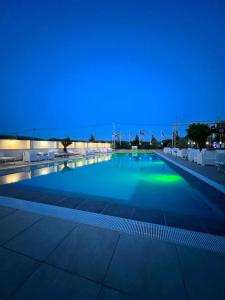 una gran piscina por la noche con luces azules en Union Villa en Shkodër