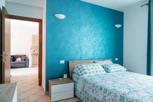 um quarto azul com uma cama e uma parede azul em Appartamento Giulia em Besnate