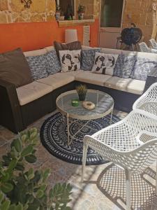 sala de estar con sofá, mesa y sillas en Large Bedroom in Boutique Style Farmhouse B&B with Pool, en Il-Pergla