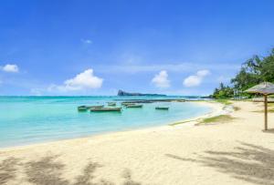 a beach with several boats in the water at Coin de Mire Attitude in Cap Malheureux