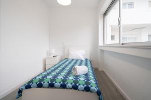 a small bed in a room with a window at Moreira 284 in Porto