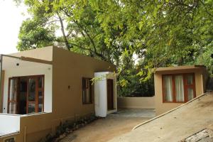 ein kleines Haus mit einem Baum davor in der Unterkunft Kandy Lotus House in Kandy