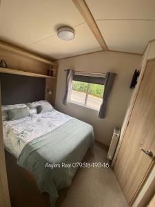 a bed in a small room with a window at Anglers Rest, with Hot Tub and Private Fishing Peg in Tattershall