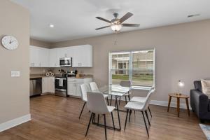 a kitchen and living room with a table and chairs at Modern 2BR 2BA New Build Condo with Garage & Patio in Wyoming