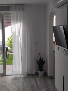 a bedroom with white curtains and a sliding glass door at Casa Rural Maestros in Albanchez de Úbeda