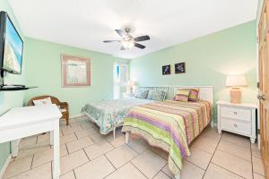 sypialnia z łóżkiem i wentylatorem sufitowym w obiekcie Beach-front Condo w Panoramic Gulf Views and Outdoor Pool w mieście Gulf Shores