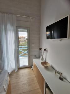 Habitación blanca con lavabo y ventana en Sea and Sand, en Elafonisos