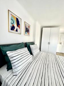 a bedroom with a bed with green and white sheets at Turqoise Central Apartaments in Bucharest