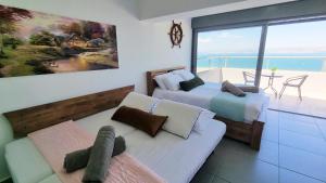 a bedroom with two beds and a view of the ocean at Galilee Triple Terrace in Tiberias