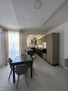 una cucina e una sala da pranzo con tavolo e sedie di Spinola Apartment a San Giuliano