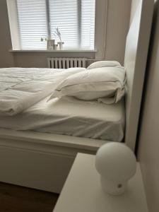 ein weißes Bett in einem Zimmer mit Fenster in der Unterkunft Skandi Appartments in Saldus city center in Saldus
