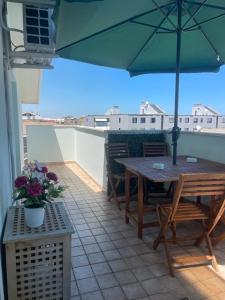 a patio with a table and chairs and an umbrella at Oasi Verde appartamento in Montesilvano
