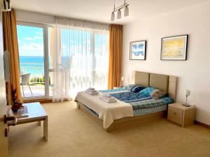 - une chambre avec un lit et une grande fenêtre dans l'établissement Apartments Bellevue, à Ravda