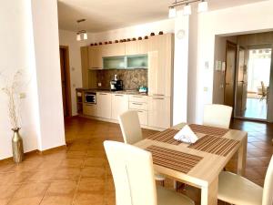 een keuken en eetkamer met een houten tafel en stoelen bij Apartments Bellevue in Ravda