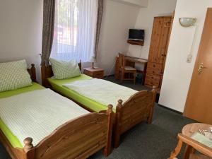 1 Schlafzimmer mit 2 Einzelbetten und einem TV in der Unterkunft Gästezimmer-Zum Krug im grünen Kranze in Pätower Steegen