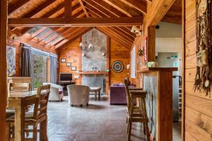 una cucina e una sala da pranzo con pareti e soffitti in legno di BOG Melania - casa en el bosque a Villa La Angostura