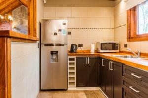拉安戈斯圖拉鎮的住宿－BOG Melania - casa en el bosque，厨房配有不锈钢冰箱和微波炉。