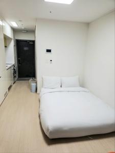 uma grande cama branca num quarto com uma cozinha em Ocean Stay Yangyang 1318 em Yangyang