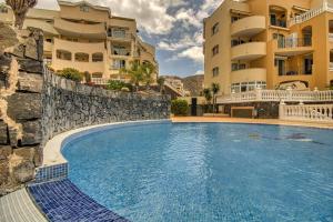 een zwembad voor twee appartementsgebouwen bij Duplex Paradise Parque Tropical 1 Los Cristianos in Los Cristianos