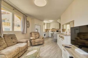 een woonkamer met een bank en stoelen en een keuken bij Duplex Paradise Parque Tropical 1 Los Cristianos in Los Cristianos