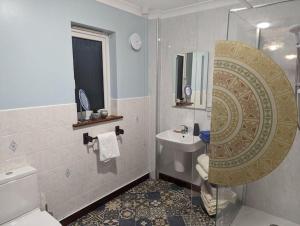 a bathroom with a toilet and a sink and a mirror at Idyllic, Luxurious Seaside Flat for 4. in Borth