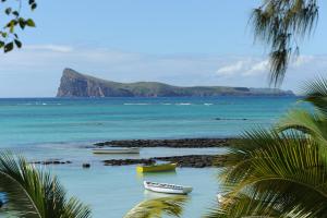 a group of boats sitting in the water on a beach at Coin de Mire Attitude in Cap Malheureux