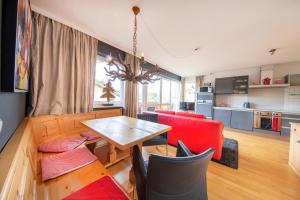 a kitchen and living room with a table and chairs at Königsblick in Königsleiten