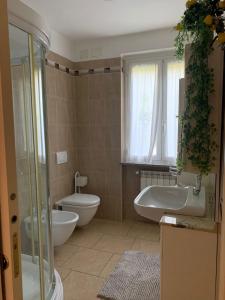 ein Badezimmer mit einer Badewanne, einem WC und einem Waschbecken in der Unterkunft Appartamento per le vacanze ,, Villa Miky,, in Pairola