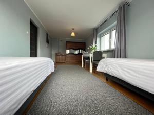 a bedroom with two beds and a dining room at Apartamenty Romano in Rzeszów
